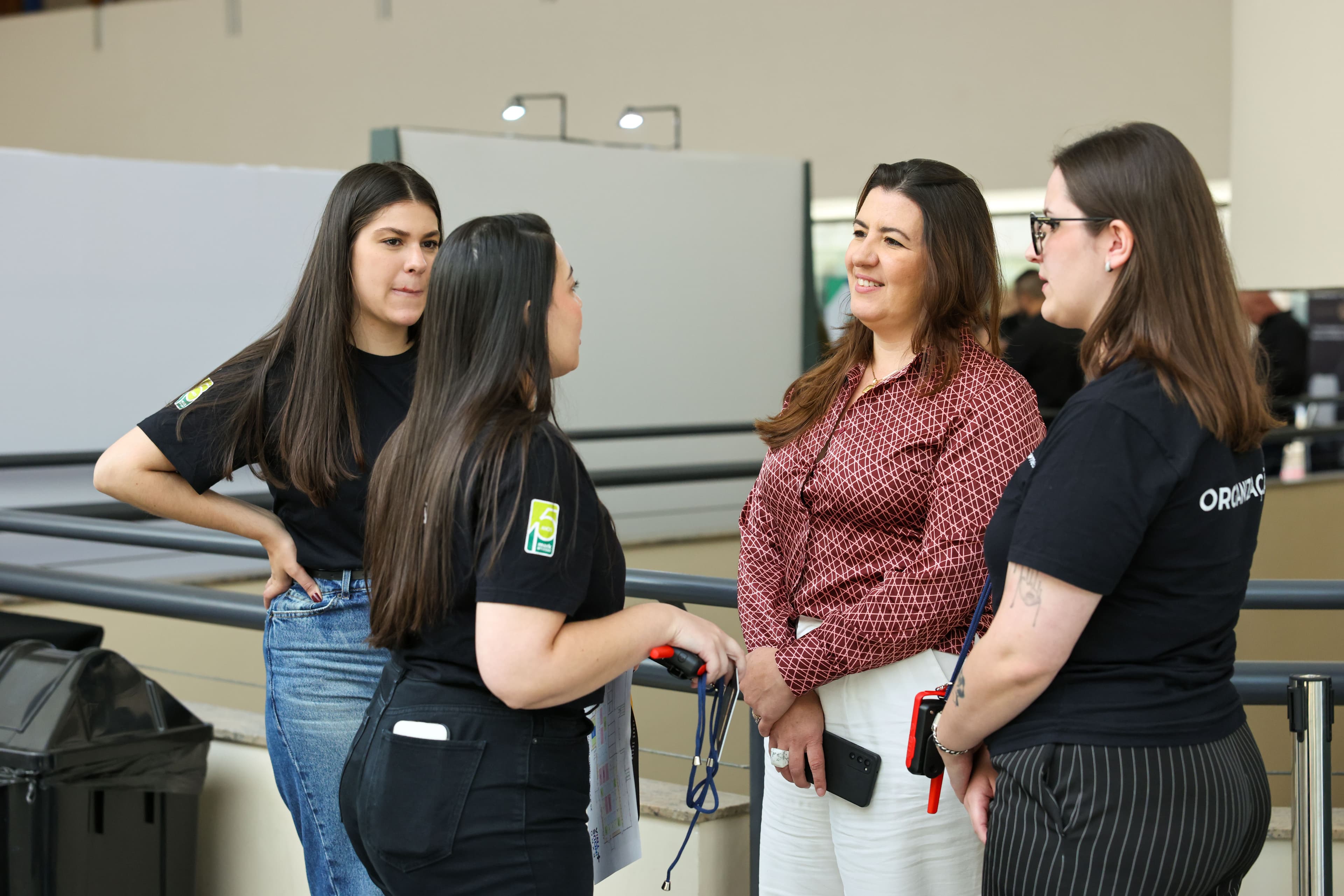 Equipe Mark Messe conversando com uma participante durante o evento